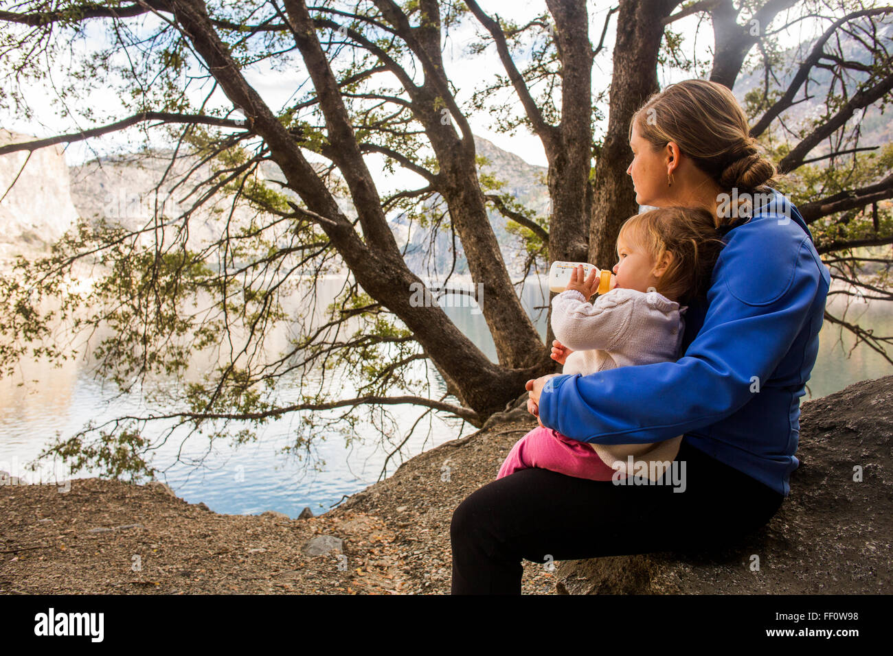 Caucasian mother and daughter sitting at Lake Banque D'Images