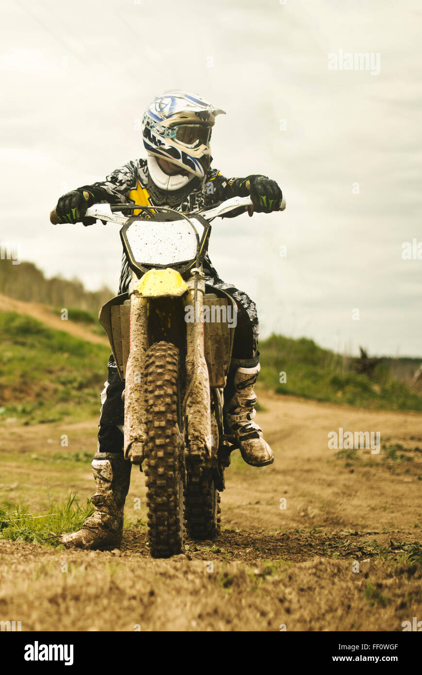 Caucasian man riding dirt bike in field Banque D'Images