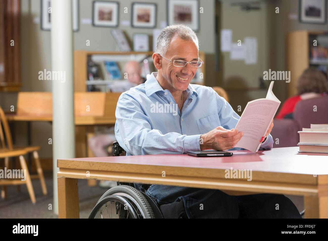 Caucasian man reading in library Banque D'Images