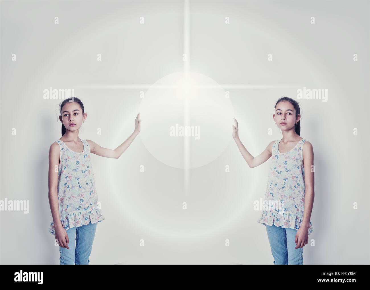 Image miroir de mixed race girl reaching for light Banque D'Images