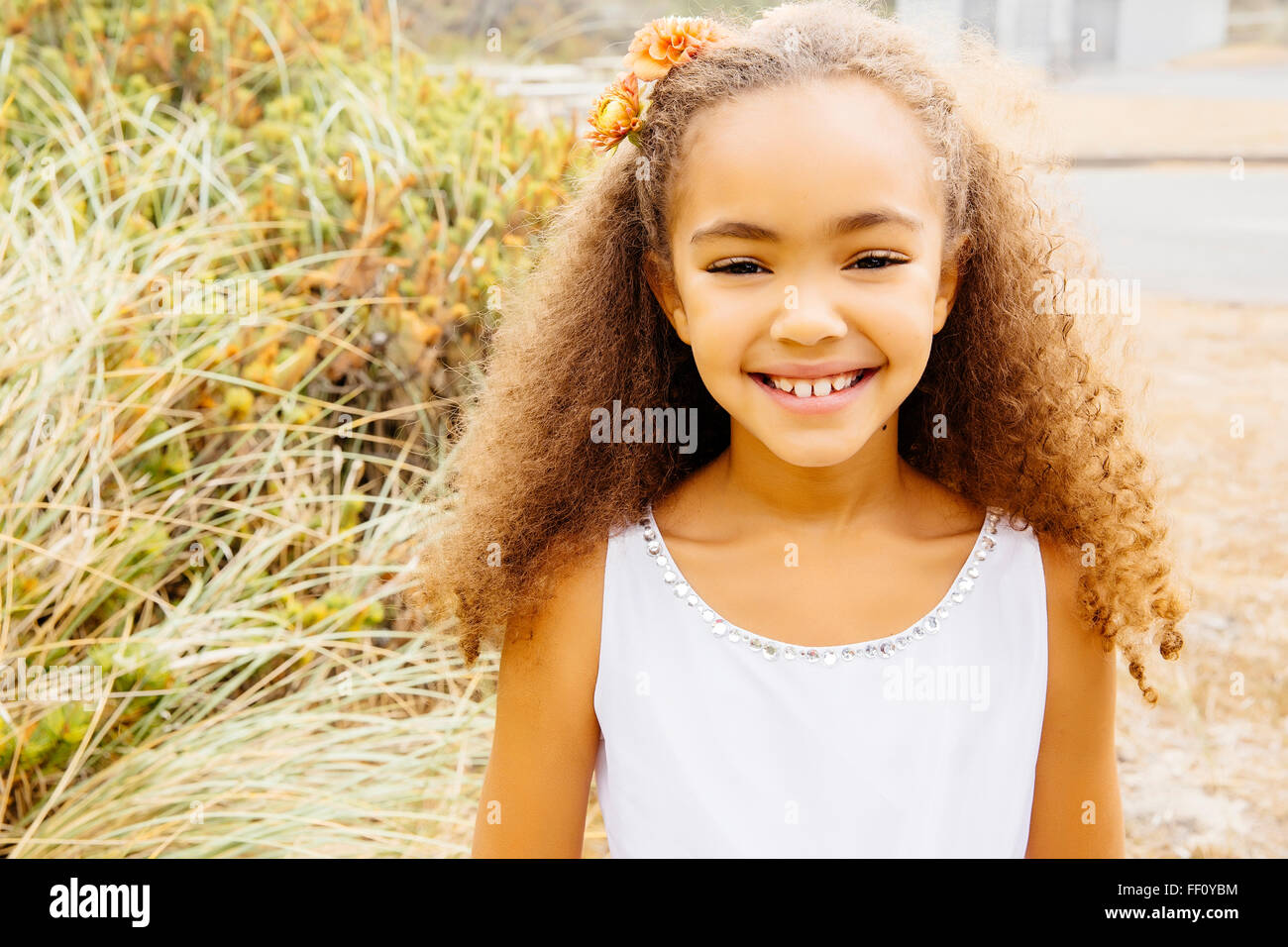 Mixed Race girl smiling on beach Banque D'Images