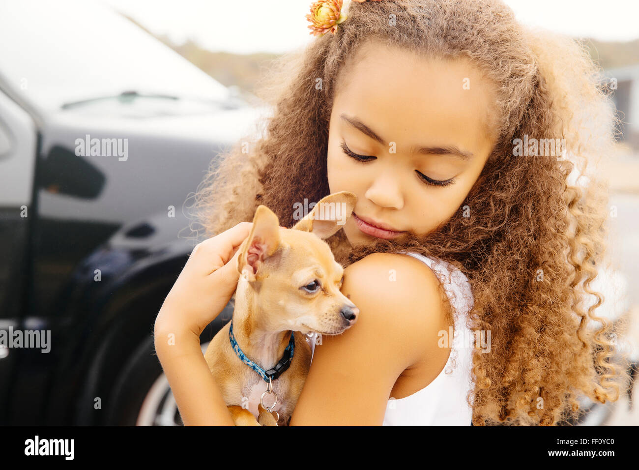 Mixed Race girl petting dog outdoors Banque D'Images