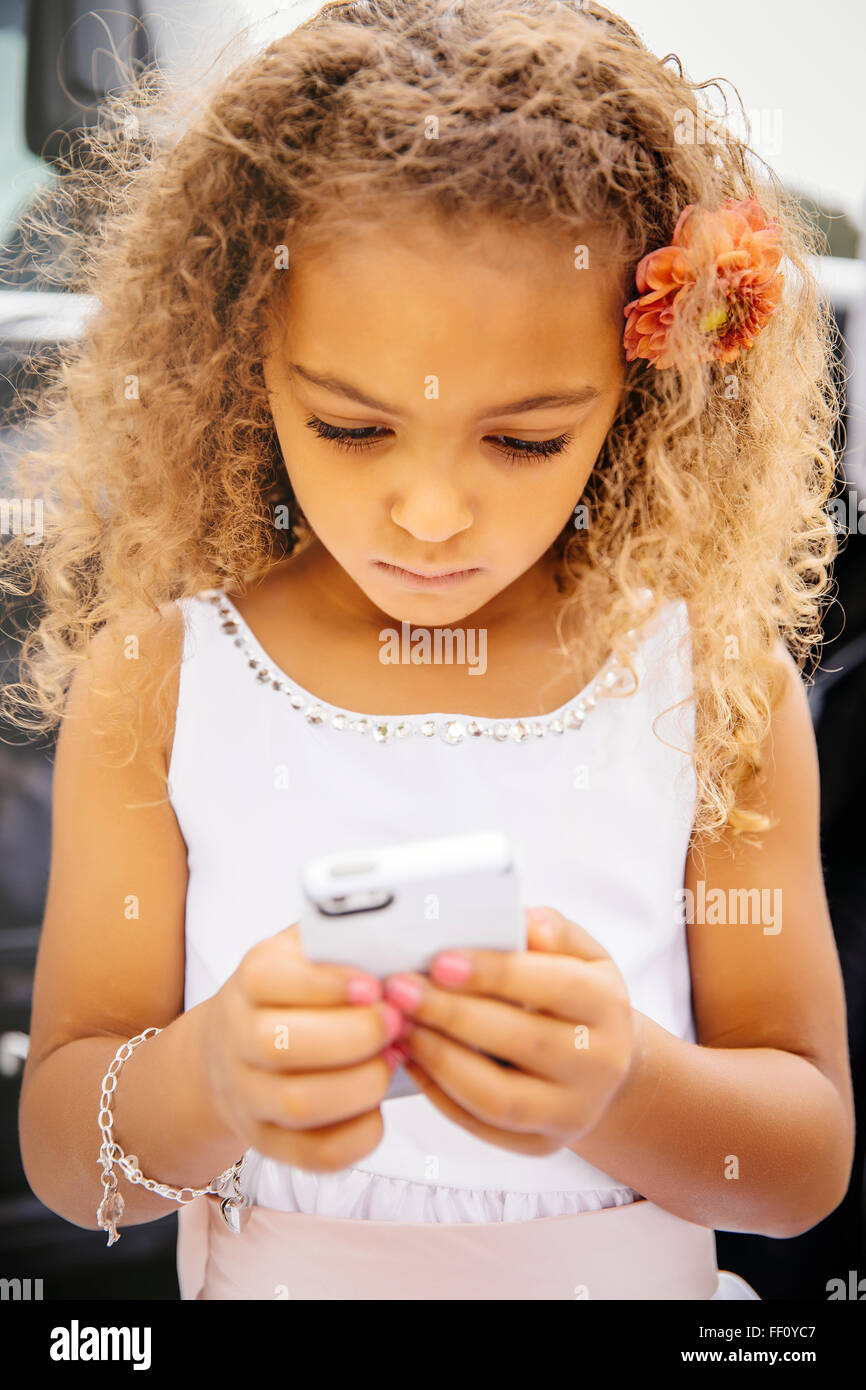 Mixed Race girl using cell phone Banque D'Images