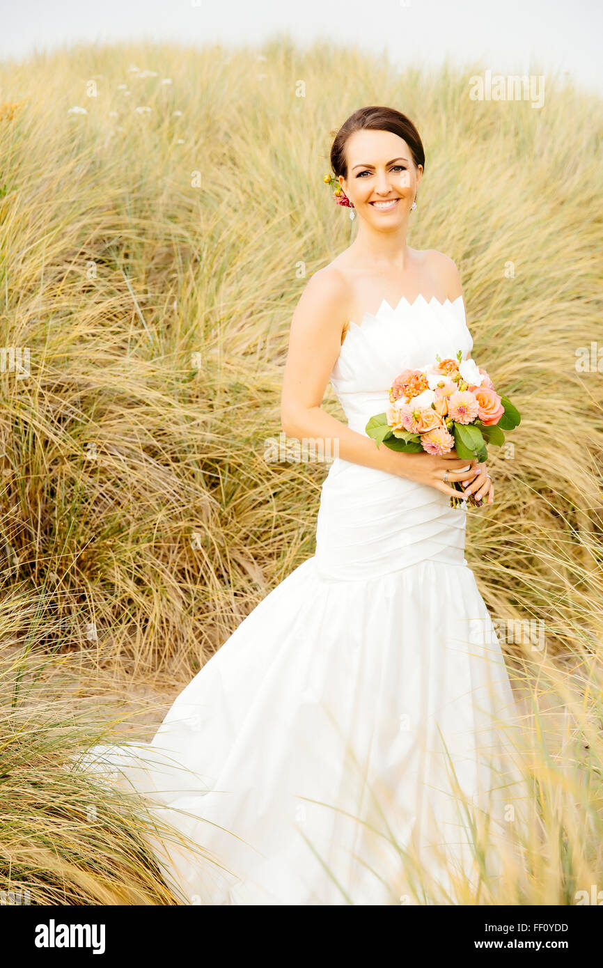 Caucasian bride standing on beach Banque D'Images