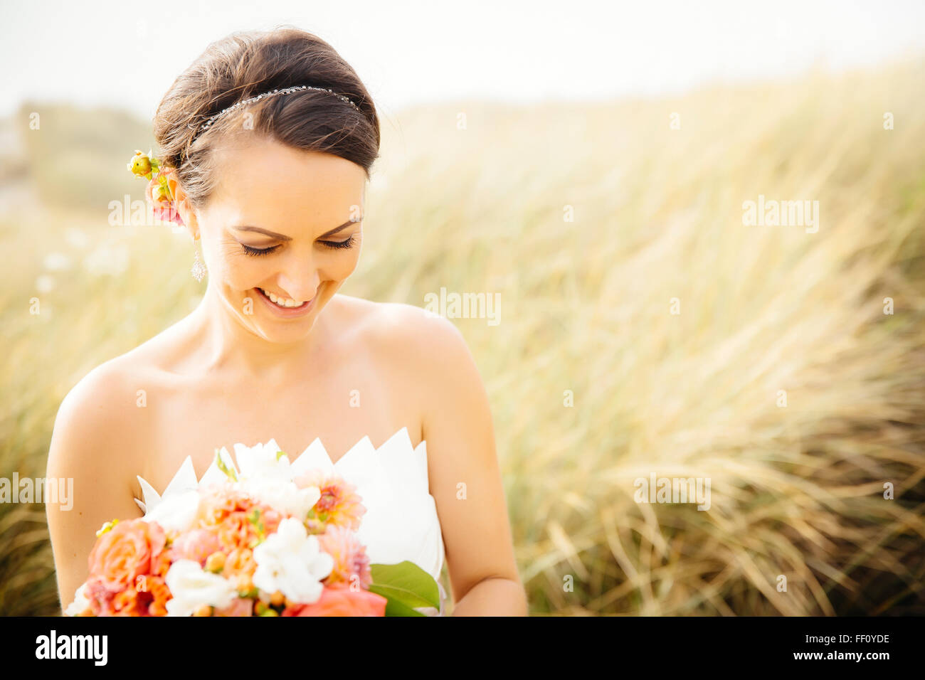 Caucasian bride standing in grass Banque D'Images
