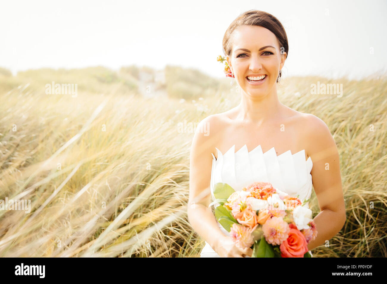 Caucasian bride standing in grass Banque D'Images