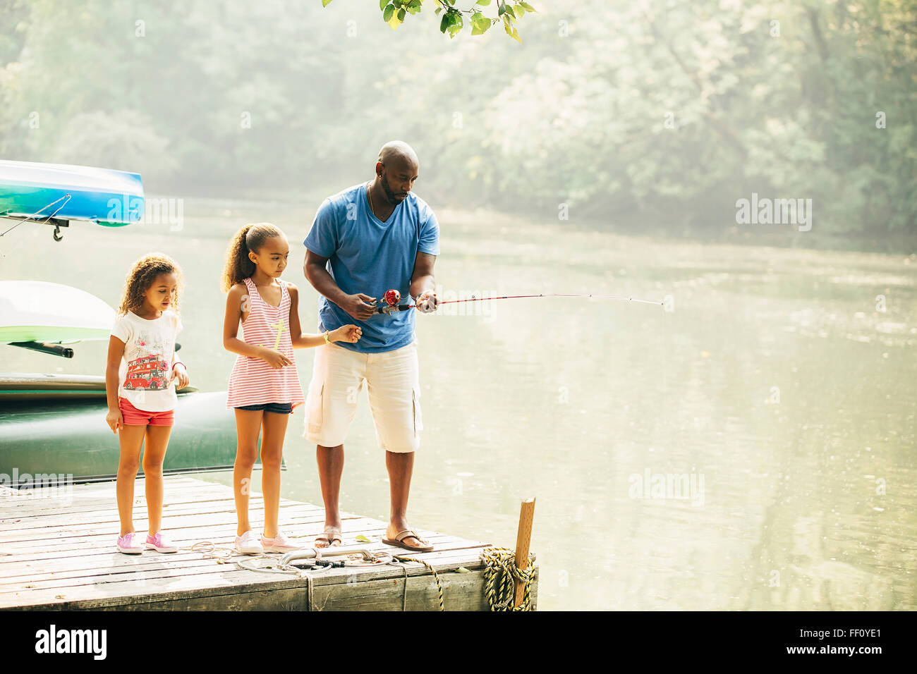 Père et filles la pêche dans le lac Banque D'Images