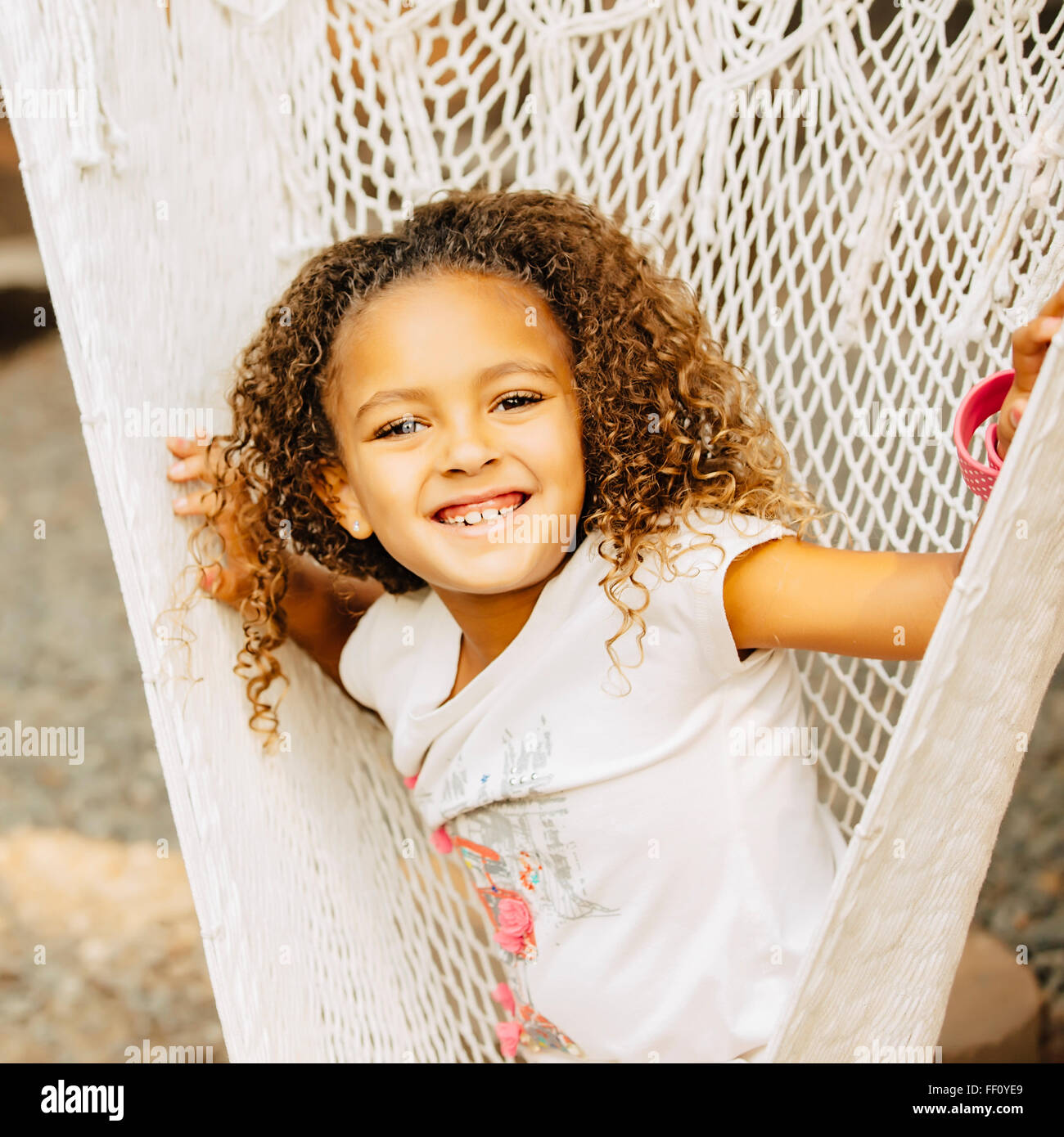 Mixed Race girl sitting in hammock Banque D'Images