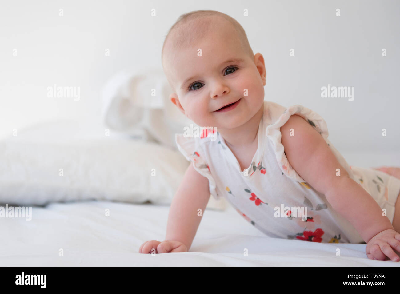 Caucasian baby girl crawling on bed Banque D'Images