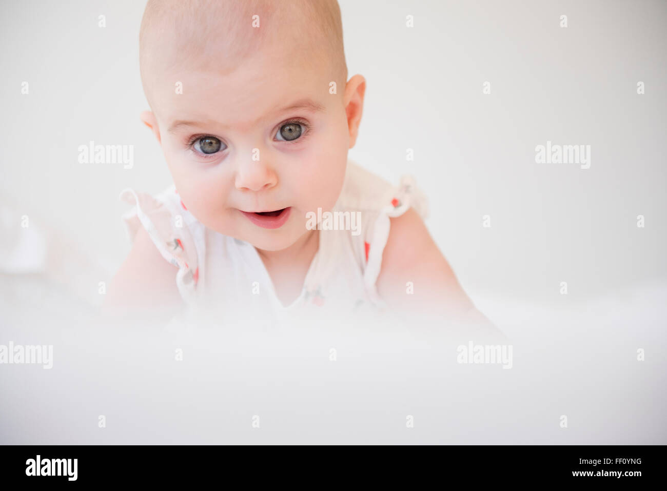 Caucasian baby girl crawling on bed Banque D'Images