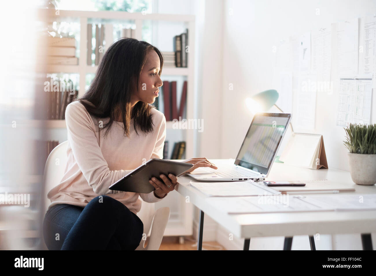 Mixed Race businesswoman using laptop Banque D'Images