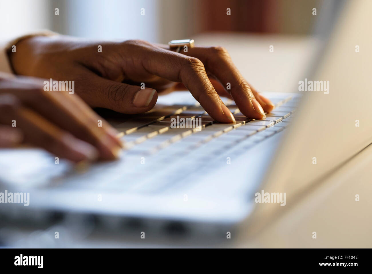 Mixed Race woman using laptop at desk Banque D'Images