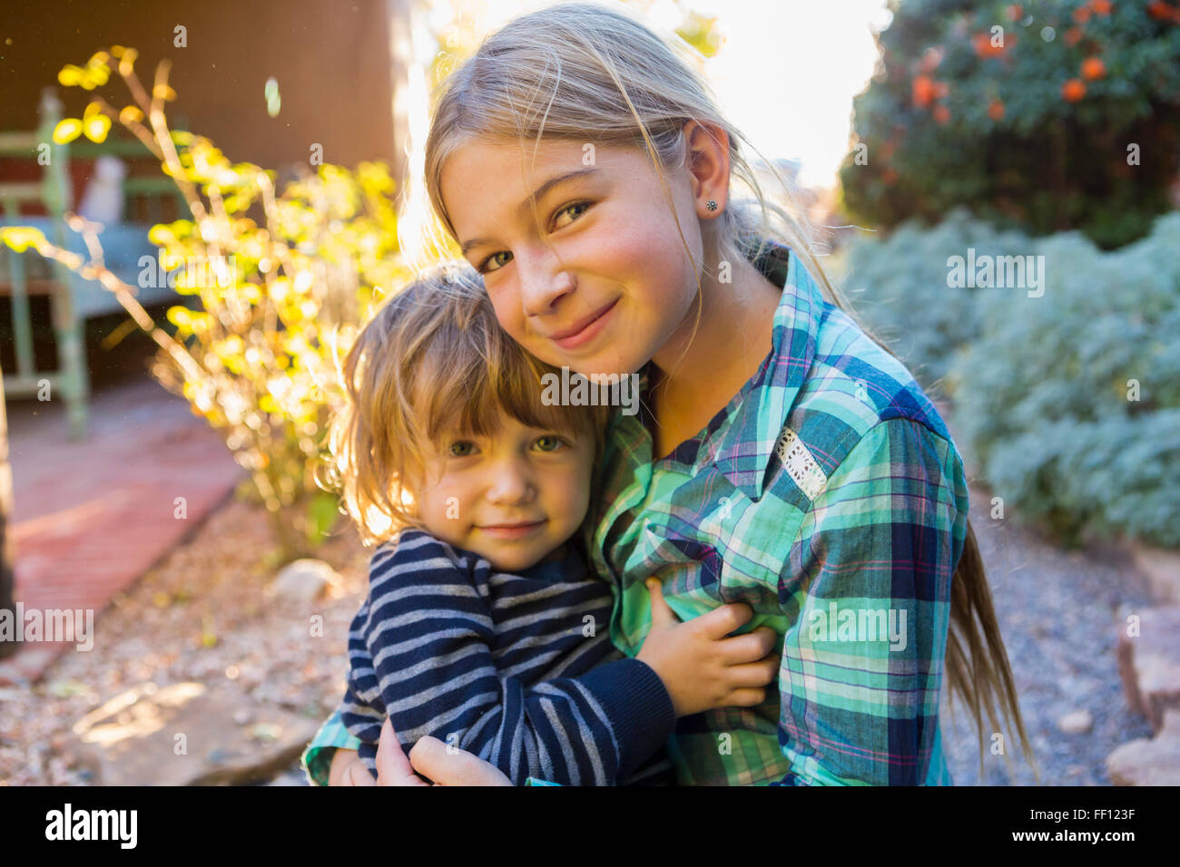 Frère et soeur de race blanche hugging outdoors Banque D'Images