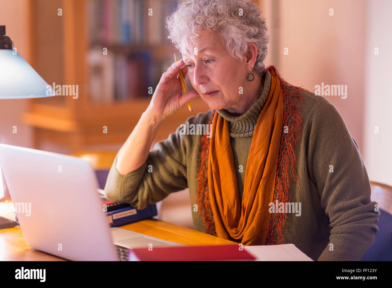 Plus mixed race woman using laptop in library Banque D'Images
