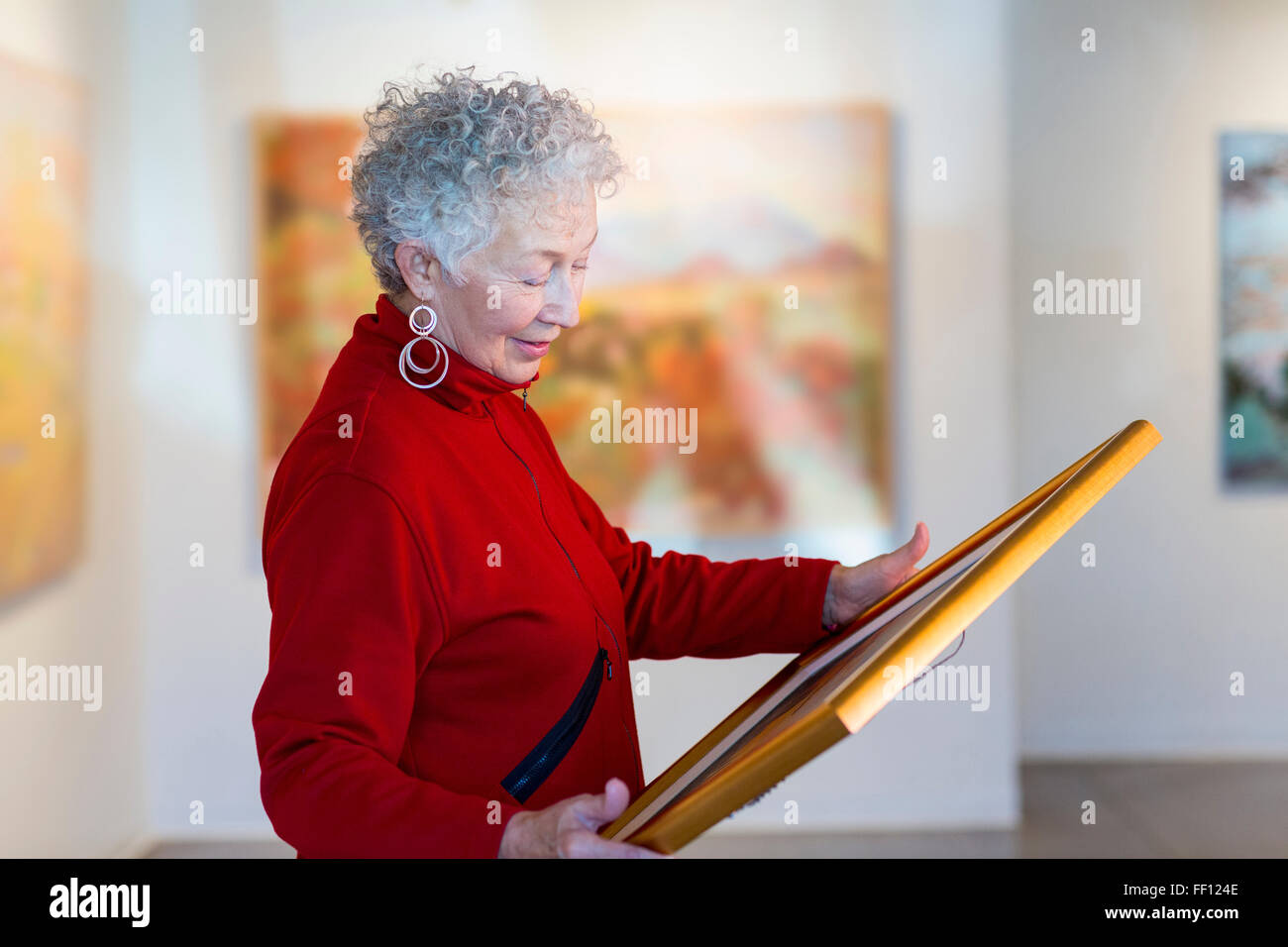 Plus mixed race woman holding photo dans art gallery Banque D'Images