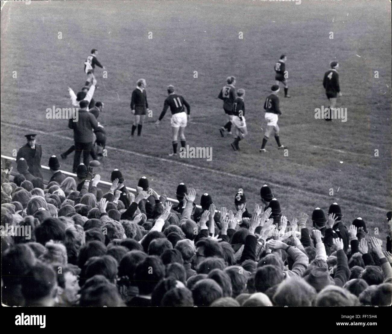 1957 - L'Université d'Oxford V. match de rugby sud-africains. Une escorte de police pour les manifestants : plus de 200 manifestants scandant ''Apartheid Out'' ont été escortés par la police d'aujourd'hui comme ils ont marché de la gare de Twickenham a commencé au stade où l'équipe de rugby sud-africain a joué l'Université d'Oxford. L'Université d'Oxford a remporté le match 6-3. Photo : montre que la police l'avant du stand à Twickenham cet après-midi- une foule de donner le salut fasciste de démonstration alors que le jeu est en cours. © Keystone Photos USA/ZUMAPRESS.com/Alamy Live News Banque D'Images