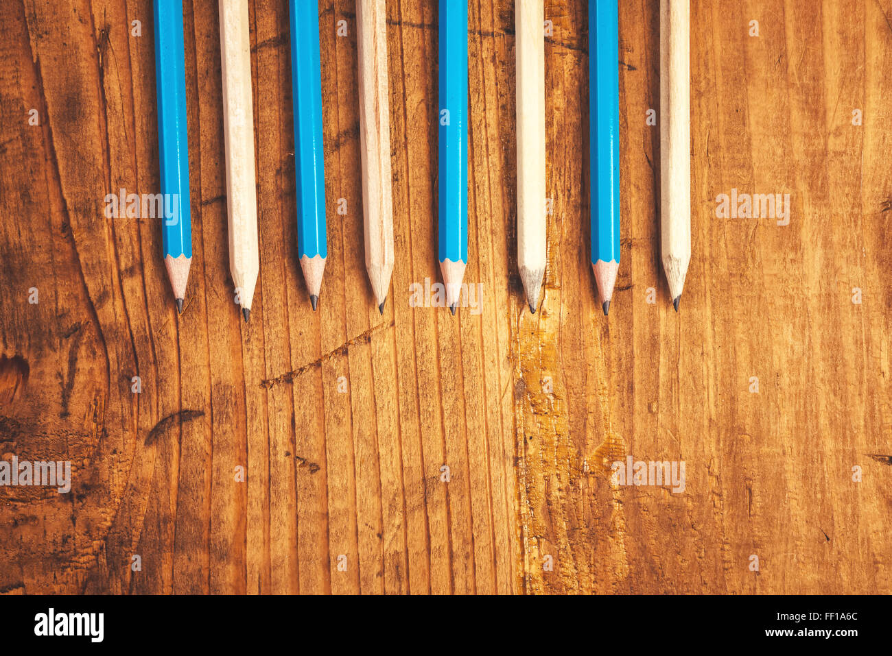 Bleu et marron crayons alignés sur une table en bois rustique, vue supérieure avec copie espace vierge Banque D'Images