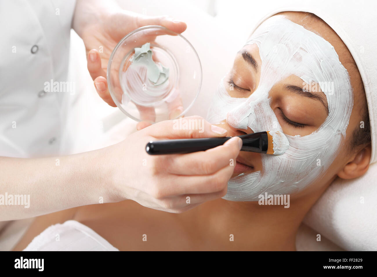 Masque hydratant cosmétique est appliquée sur le visage d'une femme.. Masque nettoyant, masque avec l'argile verte, vous détendre dans le spa Banque D'Images