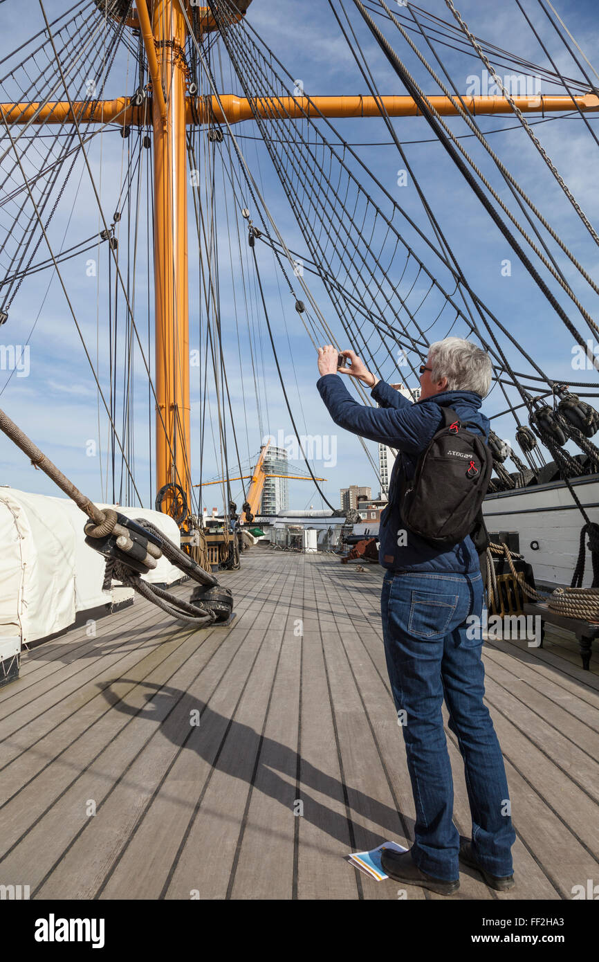 Touriste prend une photographie du gréement du pont supérieur du HMS Warrior. Banque D'Images