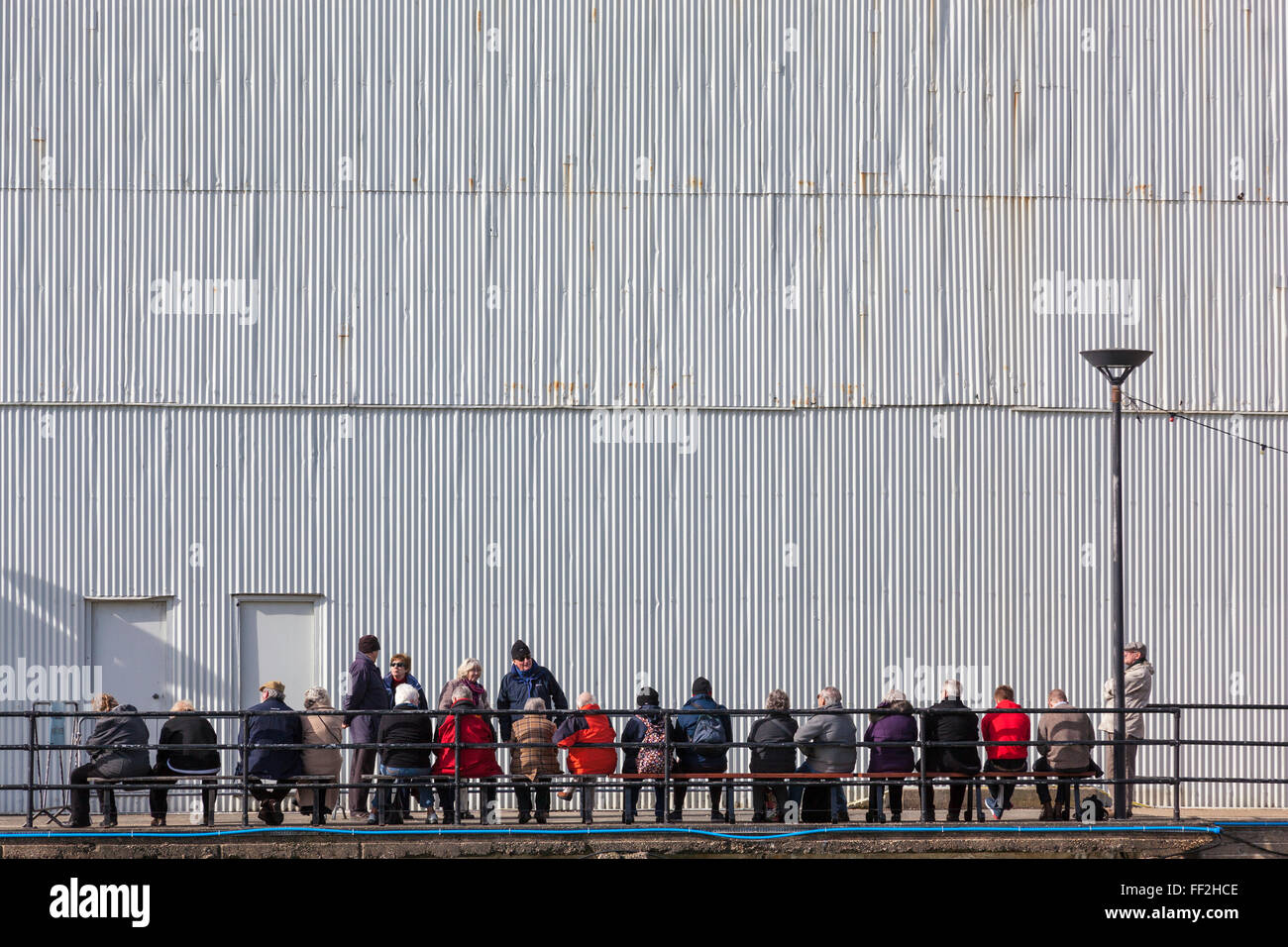 Les touristes attendre la prochaine croisière sur le port à l'extérieur d'un hangar à bateaux 4 dans le Royal Naval Dockyard, Portsmouth. Banque D'Images