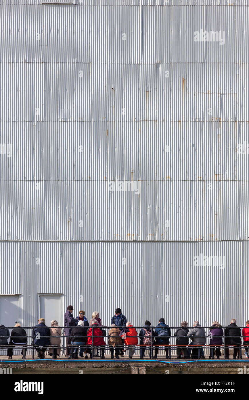 Les touristes attendre la prochaine croisière sur le port à l'extérieur d'un hangar à bateaux 4 dans le Royal Naval Dockyard, Portsmouth. Banque D'Images