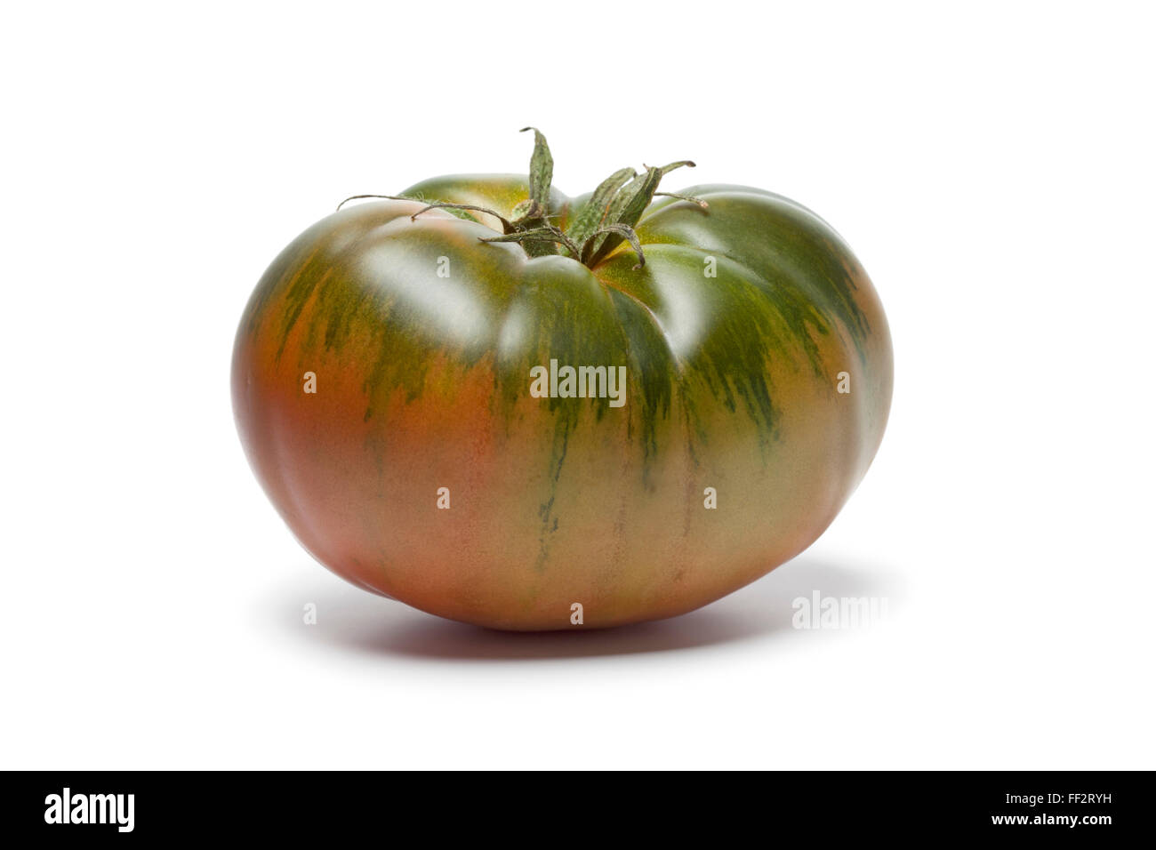 Seul frais entier RAF heirloom tomato sur fond blanc Banque D'Images