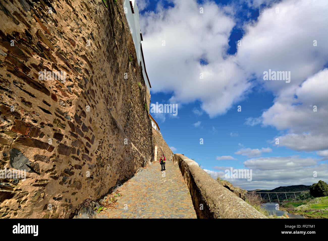 Le Portugal, l'Alentejo : Woman walking along le village médiéval des murs à la piste en Ribeirinho Mértola Banque D'Images