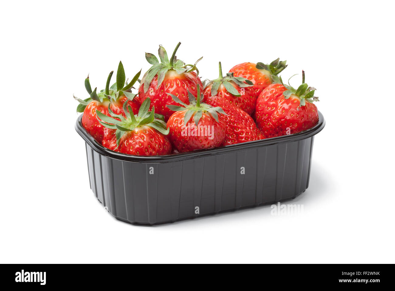 Coffret en plastique avec des fraises fraîches sur fond blanc Banque D'Images
