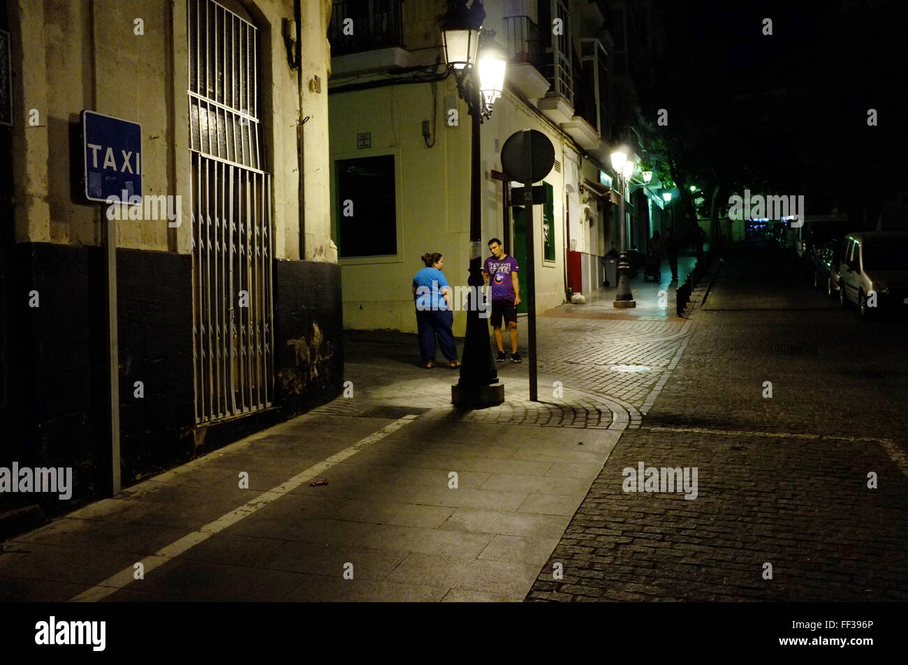 Deux personnes parlent sur un coin de rue à Cadix, Espagne Banque D'Images
