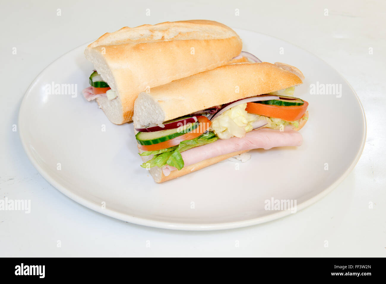 Salade de jambon et remplissant un pain coupé sur une plaque Banque D'Images