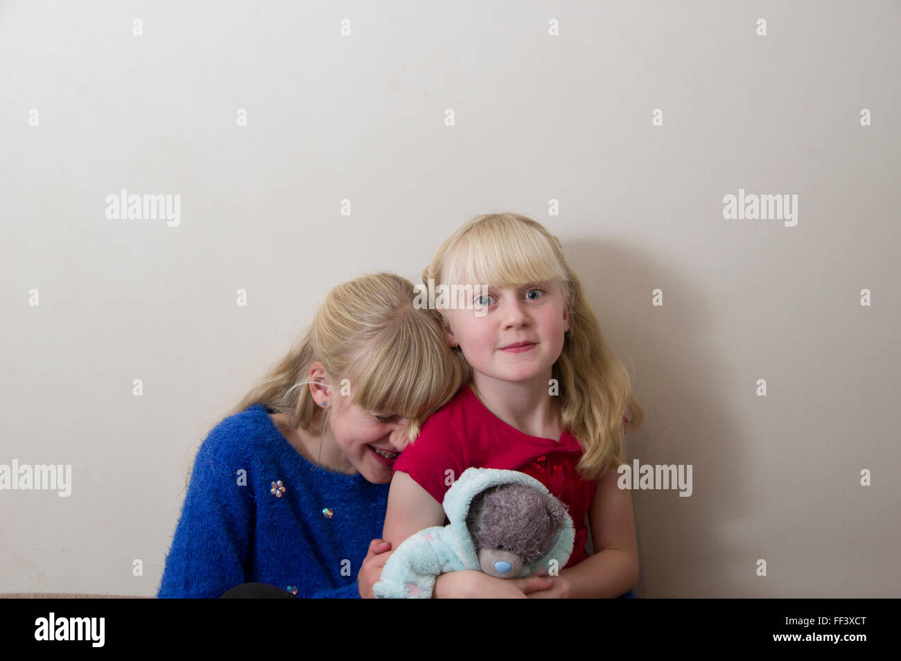 Portrait de deux jeunes filles blondes, sur un fond blanc. Banque D'Images