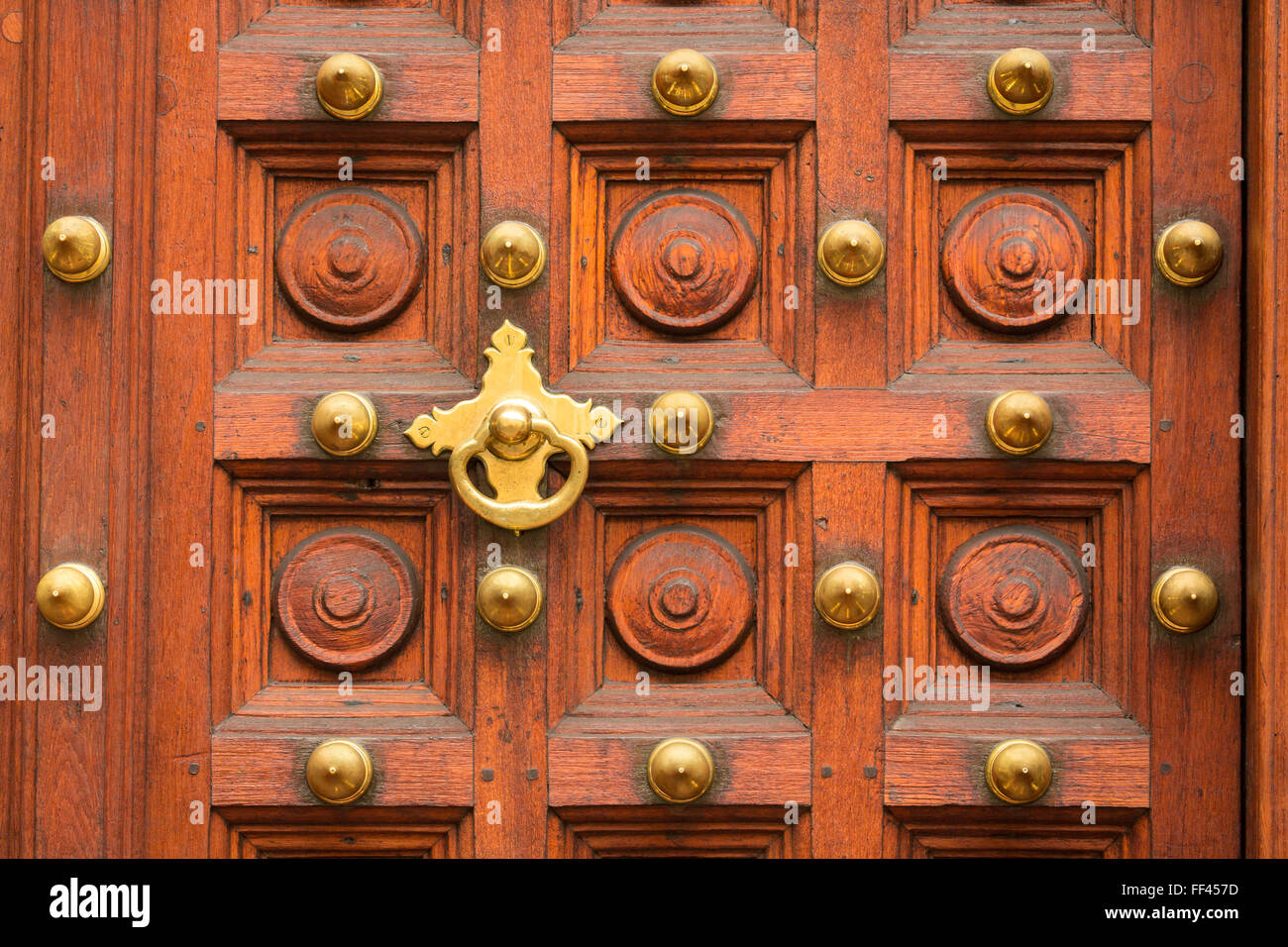 Close up de porte en bois sculpté montrant Knocker et clous Banque D'Images