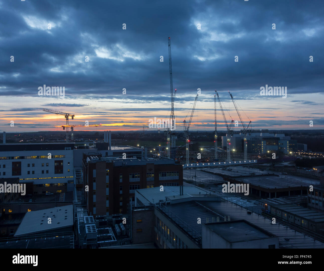 Grues sur un chantier de construction au coucher du soleil Cambridge Cambridgeshire England UK Banque D'Images