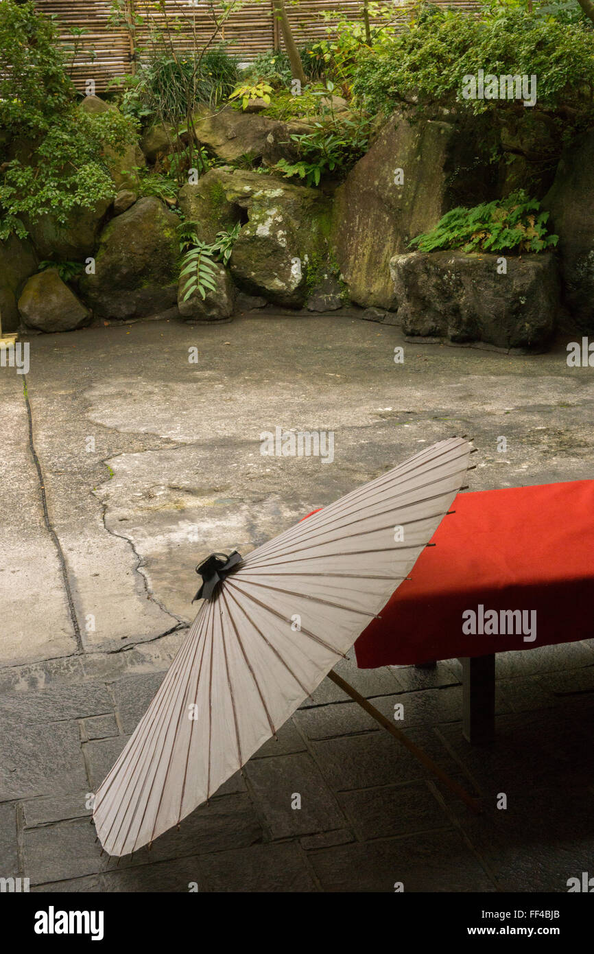 Parapluie et banc rouge dans la campagne japonaise avec le feuillage Banque D'Images