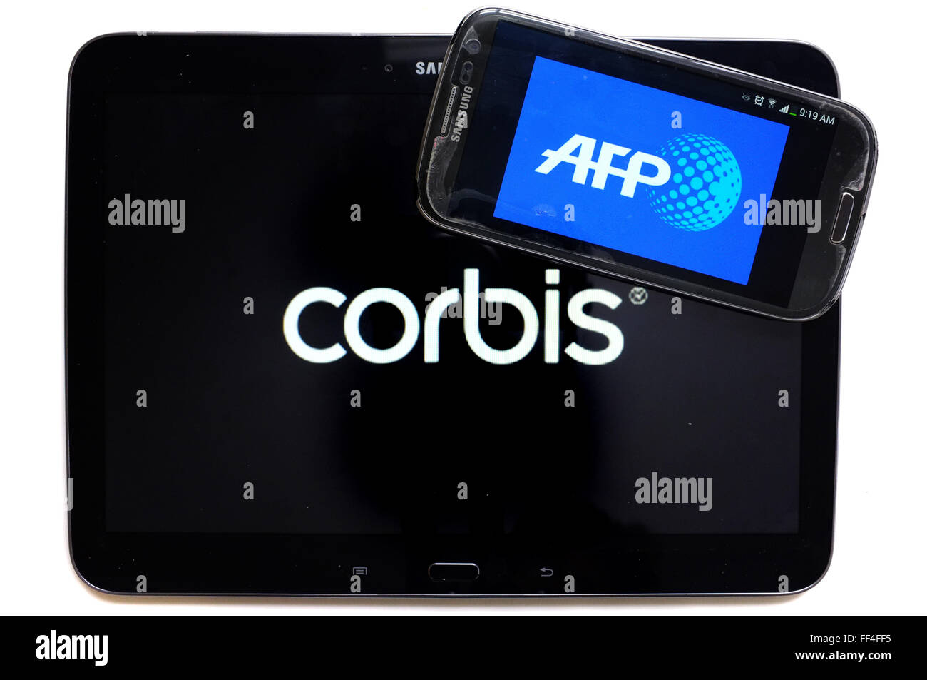 Le logo de l'AFP sur un smartphone et une tablette sur Corbis photographié sur un fond blanc. Banque D'Images