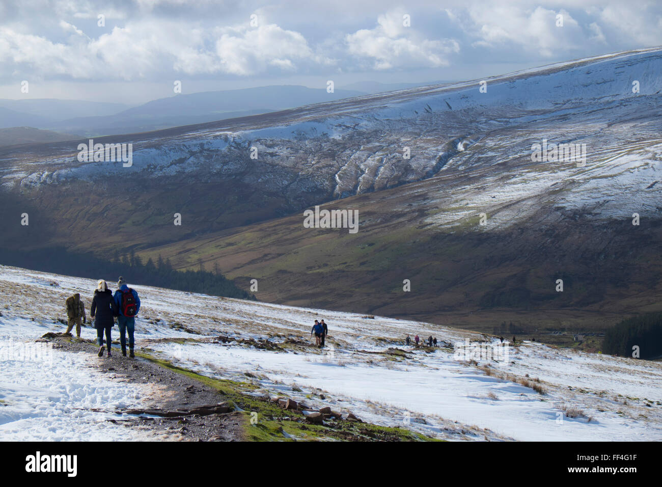 Les marcheurs sur le chemin menant au sommet du Pen Y Fan de la neige en hiver, le Parc National des Brecon Beacons, Powys, Pays de Galles, Royaume-Uni Banque D'Images