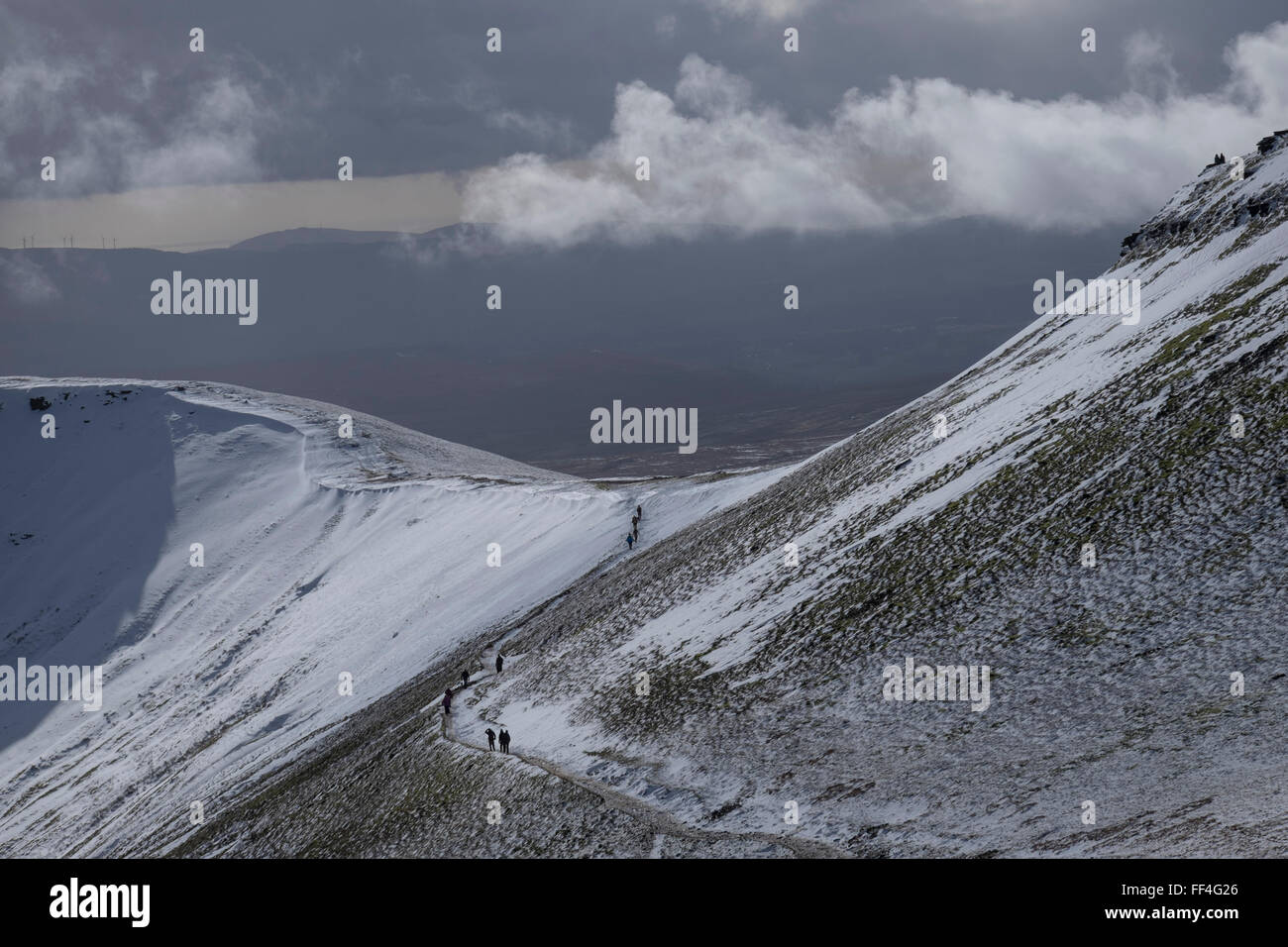 Les marcheurs sur le chemin menant au sommet du Pen Y Fan de la neige en hiver, le Parc National des Brecon Beacons, Powys, Pays de Galles, Royaume-Uni Banque D'Images