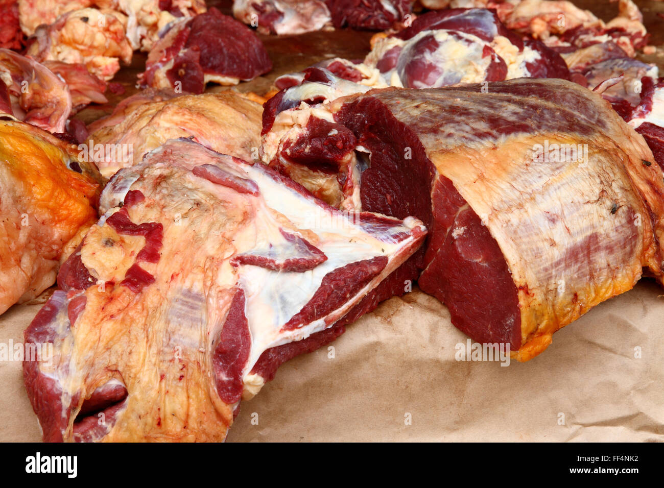 De grands morceaux de viande crue, la viande bovine, s'asseoir sur un compteur en plein air chaud dans un marché à Kampala, Ouganda. Banque D'Images