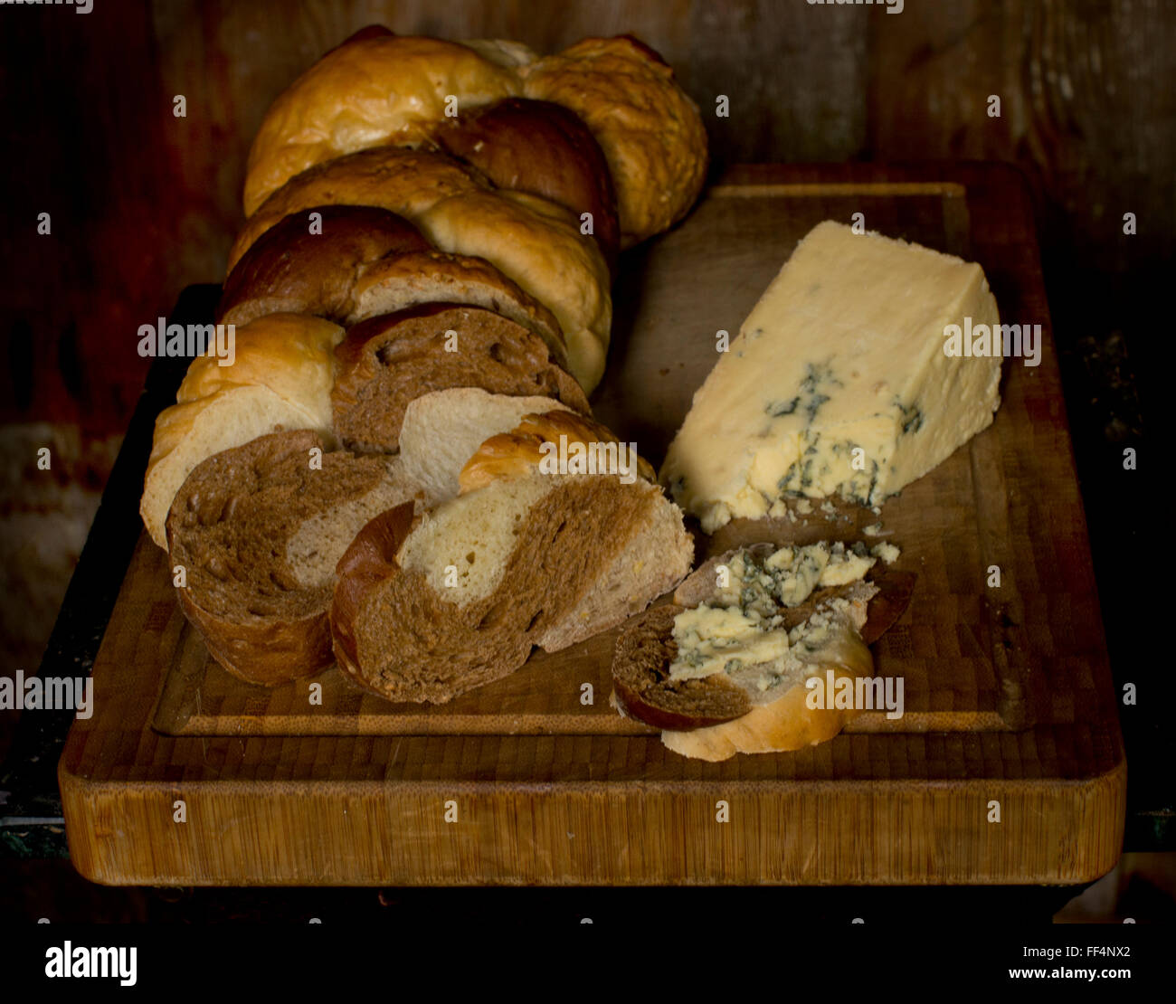Miche de pain tressé et wedge de Stilton cheese sur une planche à découper Banque D'Images