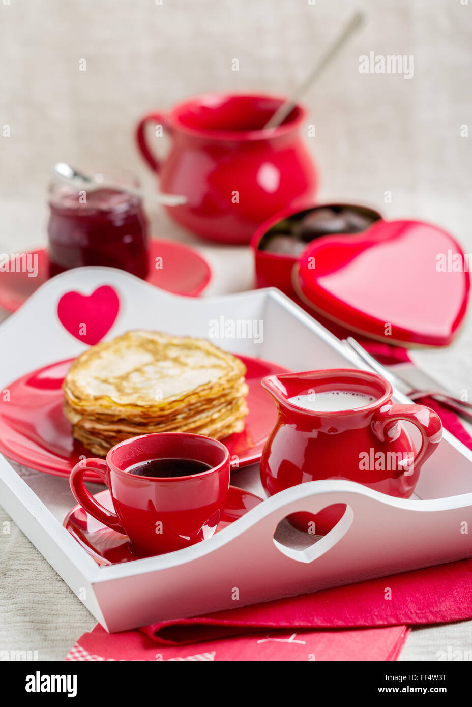 Le petit-déjeuner. Crêpes et café au lait sur un plateau pour la Saint-Valentin. Focus sélectif. Banque D'Images