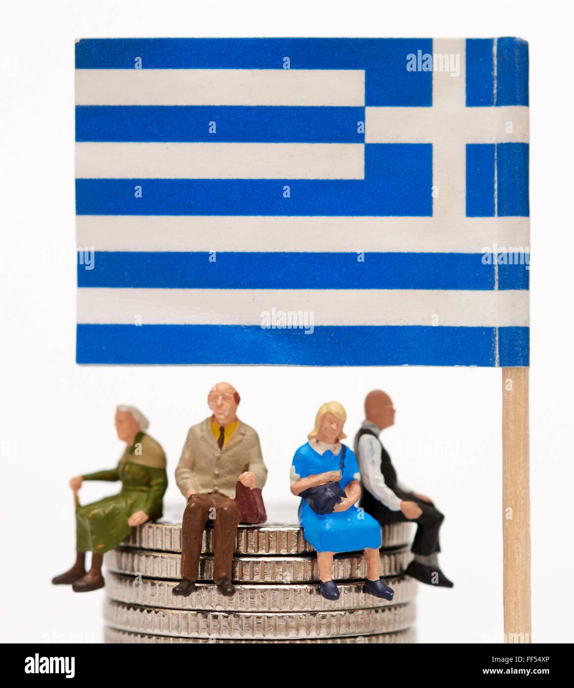Figurine miniature des gens assis sur des crédits sous pavillon grec Banque D'Images