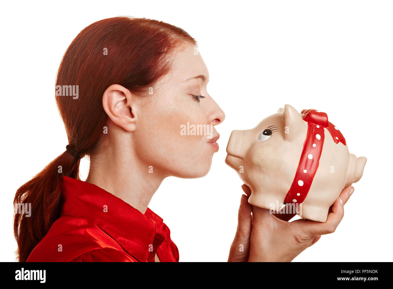 Redhaired woman kissing une grosse tirelire Banque D'Images