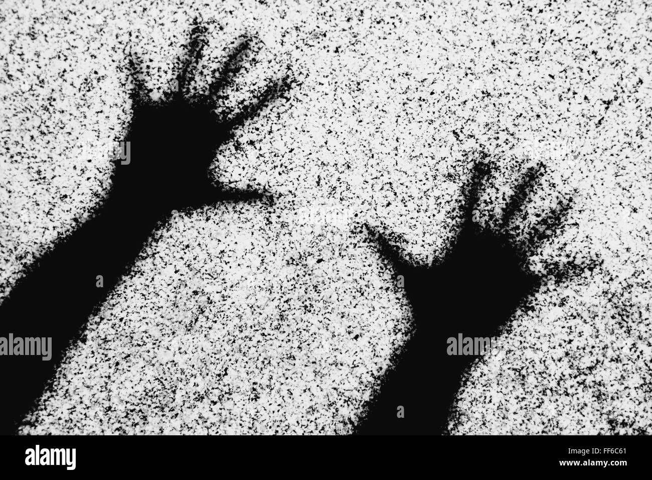 Ombre de deux mains humaines avec les doigts tendus sur un mur. Banque D'Images