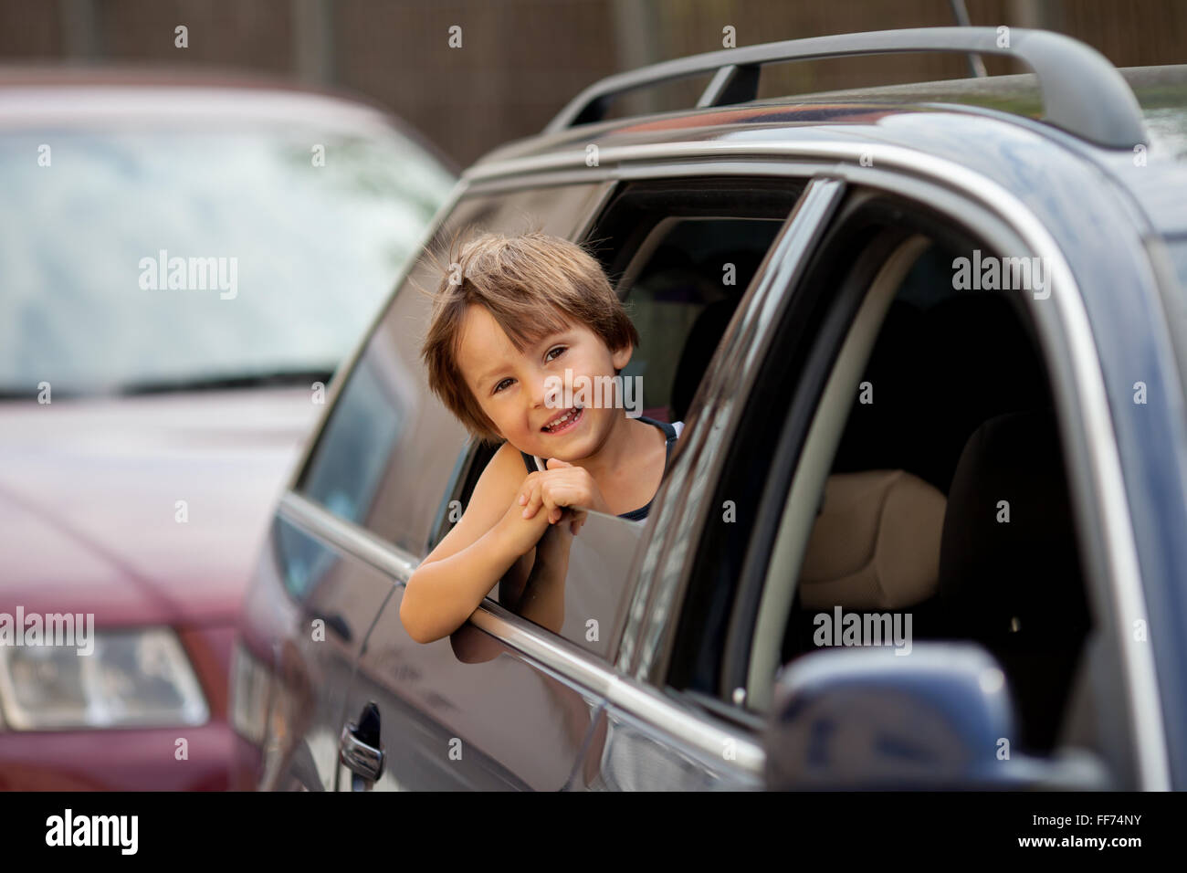 Mignon petit enfant, garçon, regardant par la fenêtre d'une voiture, smiling Banque D'Images