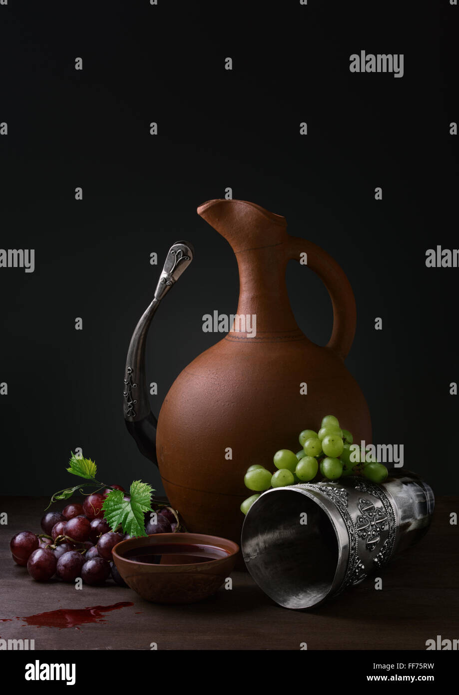 Coupe de vin de raisins et de l'avertisseur sonore potable cruche sur une table en bois Banque D'Images