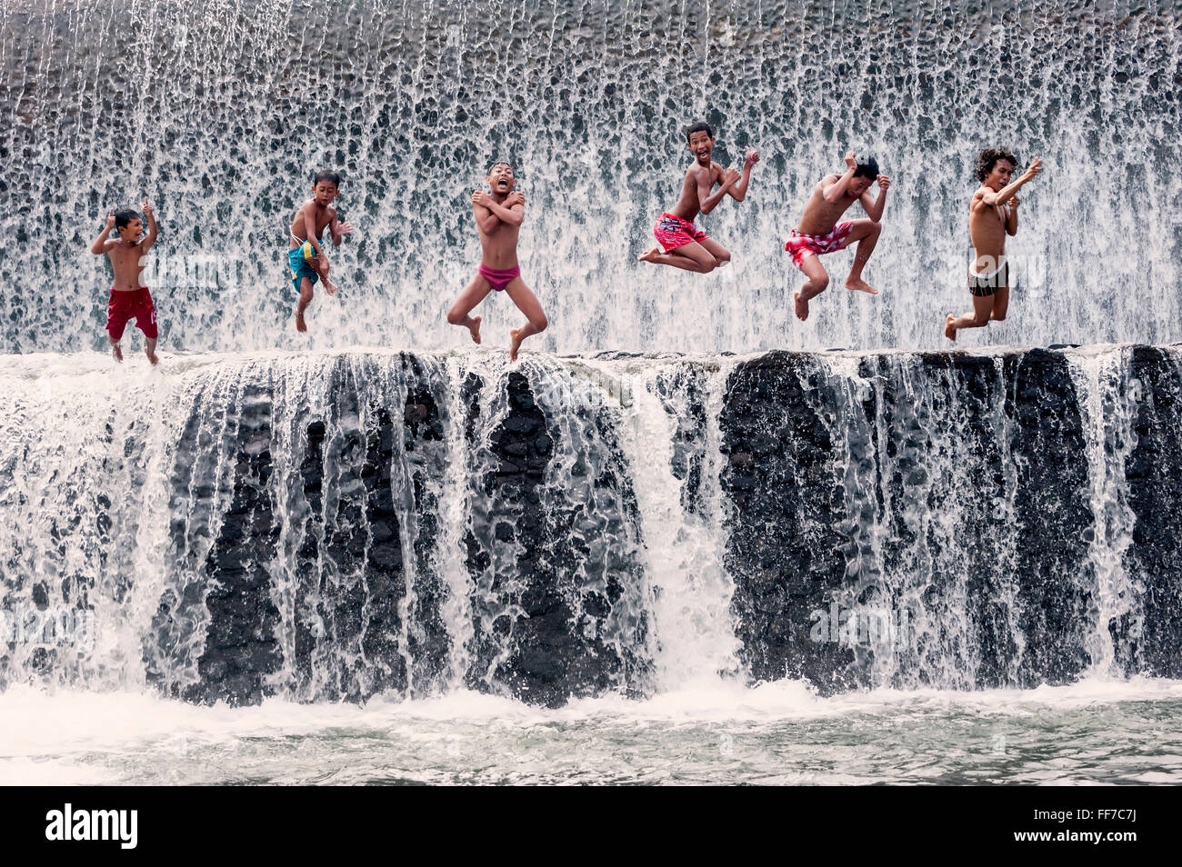 Les garçons sautent dans une cascade et s'amuser, Bali, Indonésie Banque D'Images