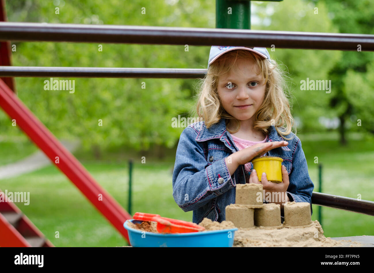 Belle blonde girl playing in playground Banque D'Images