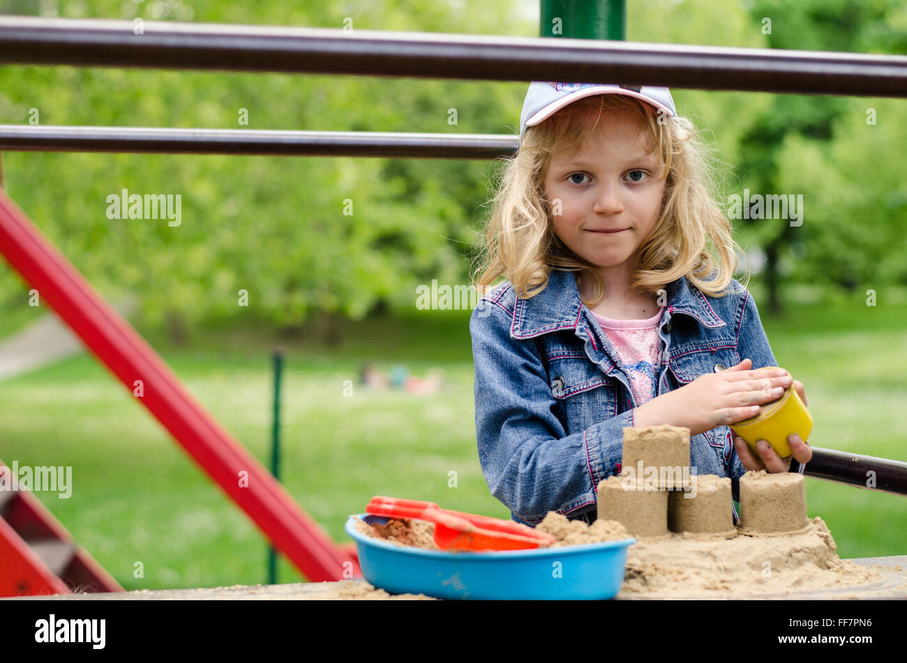 Belle blonde girl playing in playground Banque D'Images