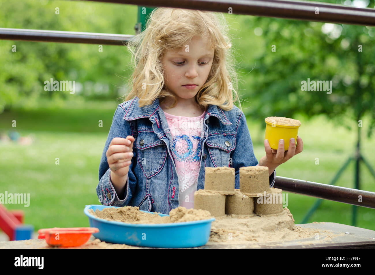 Belle fille blonde jouant avec le sable Banque D'Images