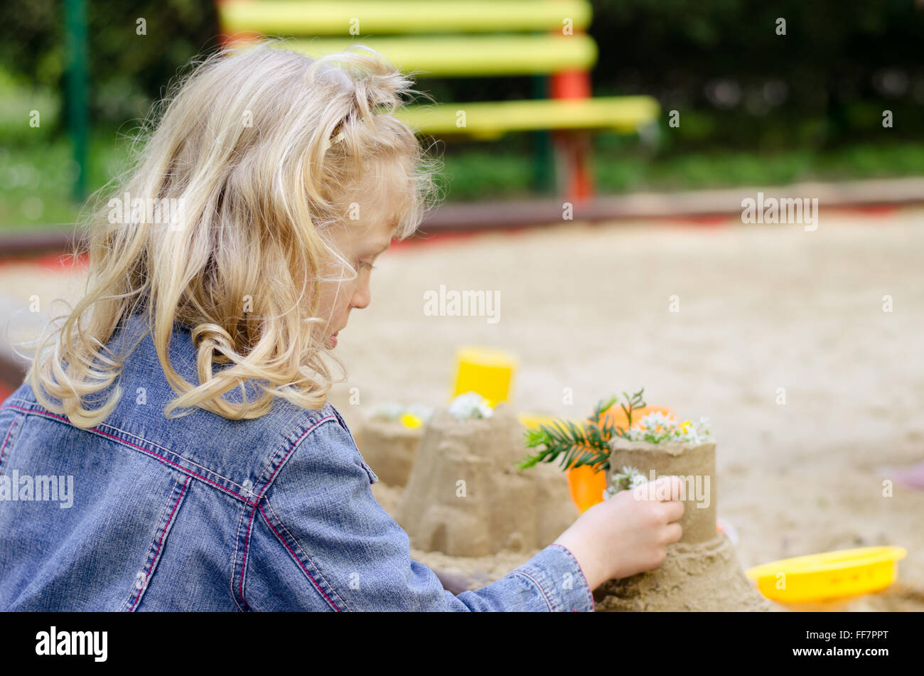 Belle blonde girl playing in playground Banque D'Images